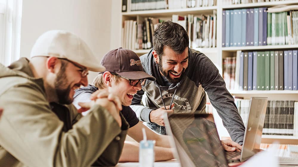 Three laughing male students